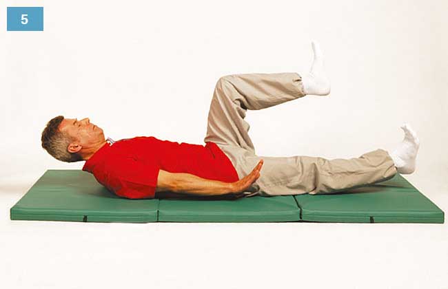 Ćwiczenie w leżeniu na plecach, głowa uniesiona, nogi nad materacem, jedna zgięta druga wyprostowana